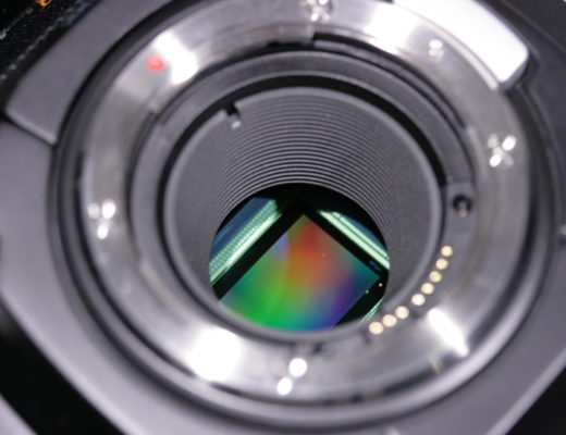 Closeup of the sensor in a Blackmagic Ursa Mini 4.6K camera. The sensor surface appears as a rainbow-coloured rectangle.