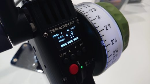 Handheld remote focus control device with distance information displayed.