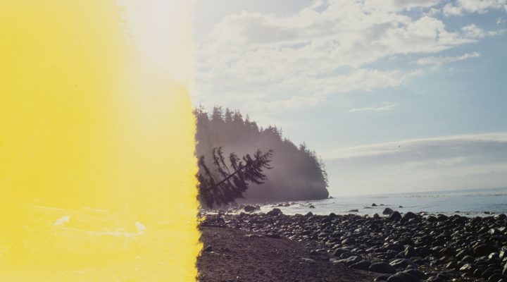 Photo of a rocky, alpine shoreline taken at the beginning of a roll of film, where half the frame has been erased by exposure to light.
